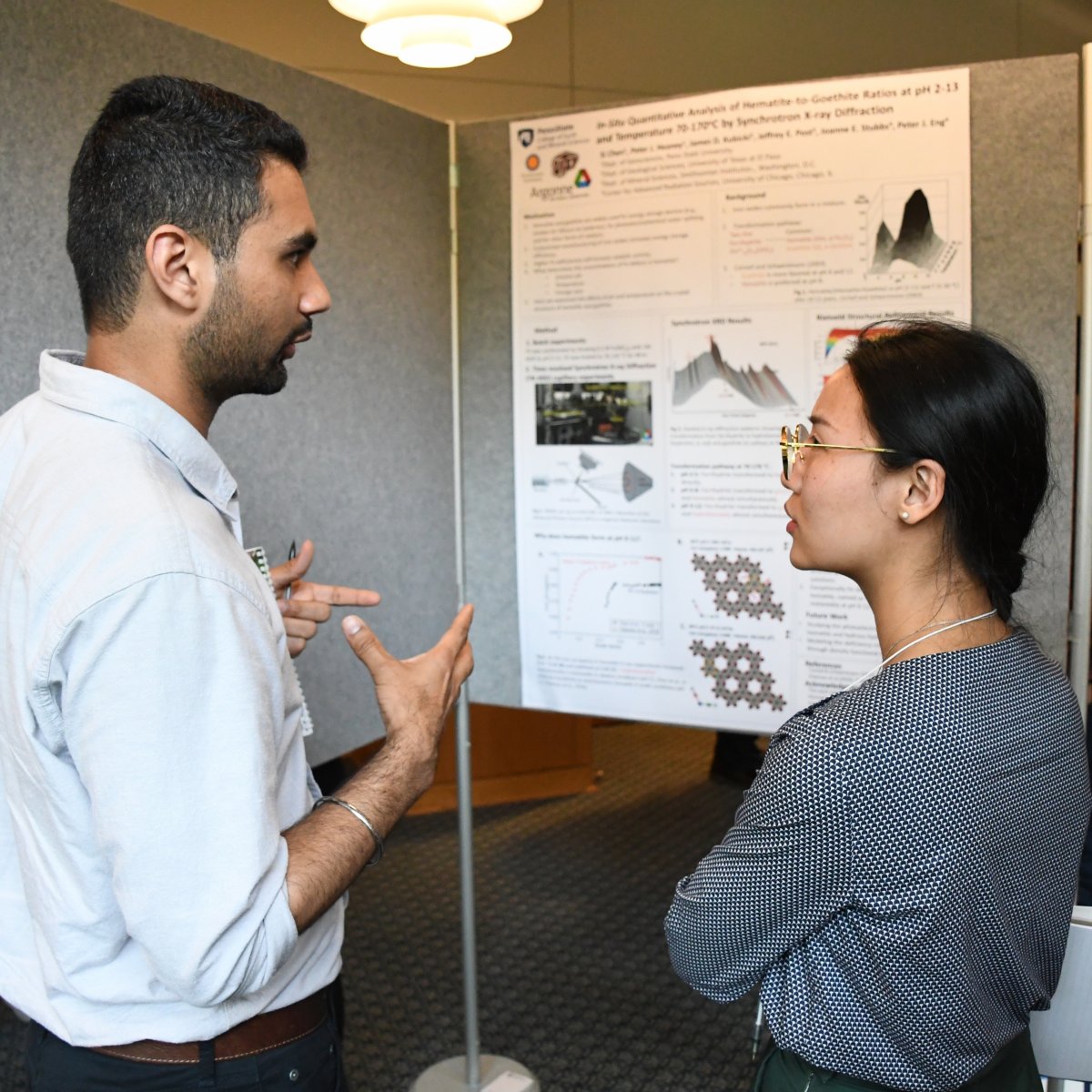 Two people speaking at poster session