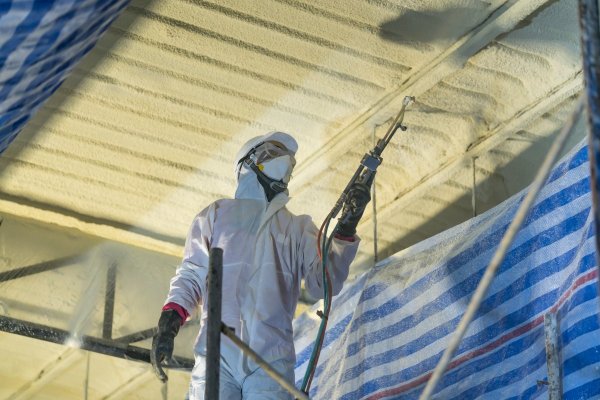 Technician spraying foam insulation