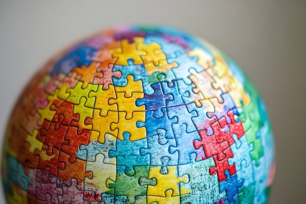 A globe made up of colorful puzzle pieces, each piece representing a different nation or community working together to form a whole