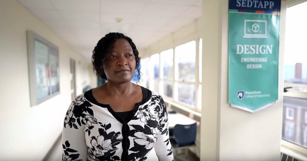 Esther Obonyo walking down a brightly lit hallway