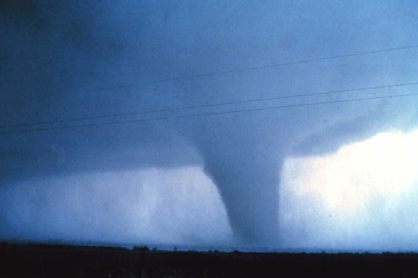 Huge dark cloud with a dark funnel coming down and touching the earth