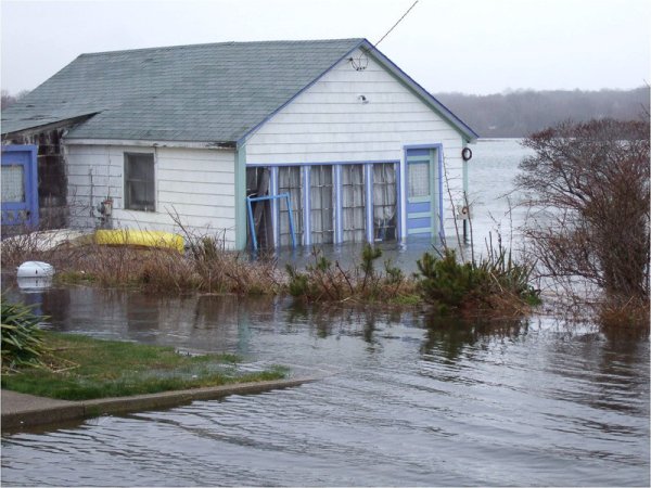 white house with blue trim surrounded by flood water