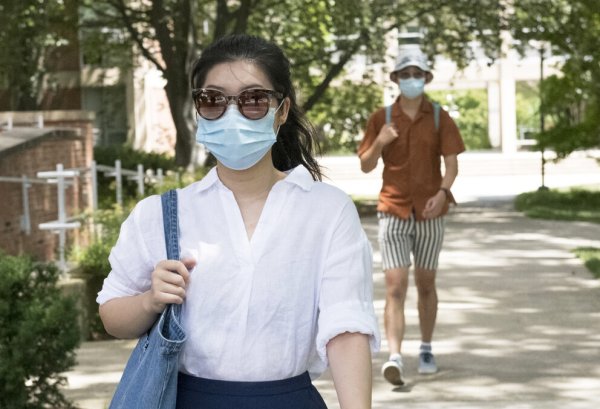 2 students walking on campus wearing masks