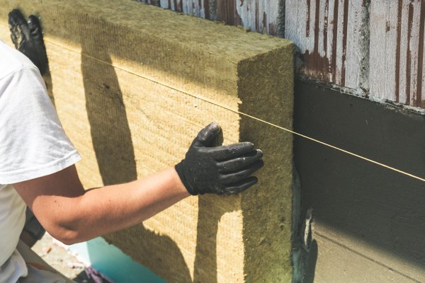 Worker installing insulation on a passive house facade
