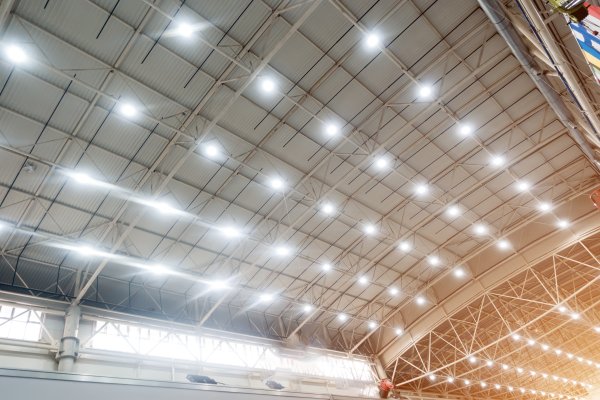 Overhead lighting shines from the ceiling in a large pavillion