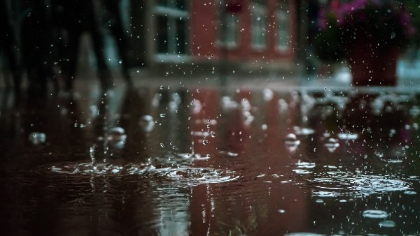 Rain falls in puddles in a city