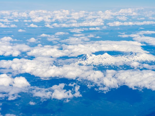 Clouds hang in the air over a mountainous landscape