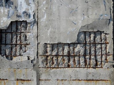 Cracked cement reveals rusty steel