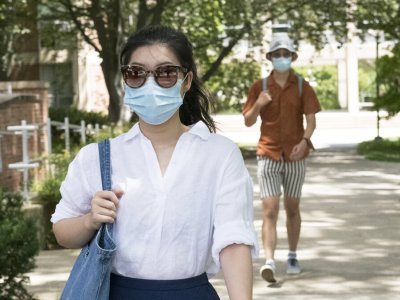 2 students walking on campus wearing masks