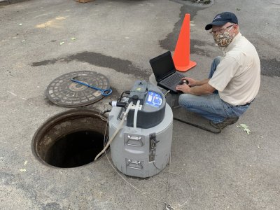 Man taking water samples from manhole