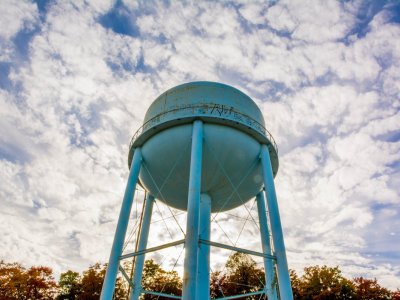 A water tower from below with a cloudy sky
