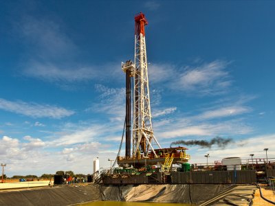 View of a land drilling rig across a sump pit