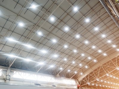Overhead lighting shines from the ceiling in a large pavillion