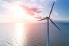 Sunset behind a wind turbine in the ocean